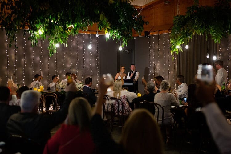 Wedding Toast given by a groom and room raises their glasses