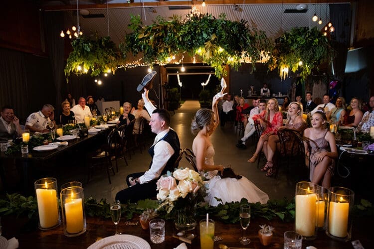Married couple play the shoe game at their wedding reception at osteria weddings