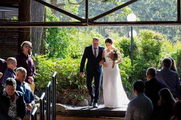 Bride walking down the aisle at Cedar Creek Lodges in Tamborine 
