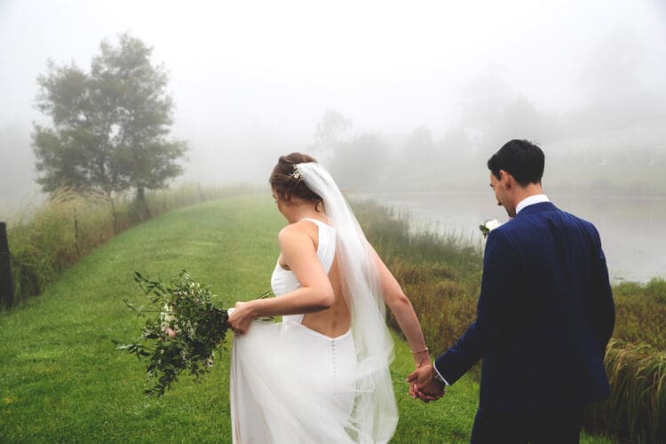 a couple holds hands on their wedding day
