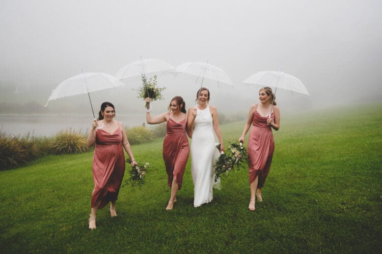 Bride and bridesmaids walking in the rain at Ocean View Estates wedding