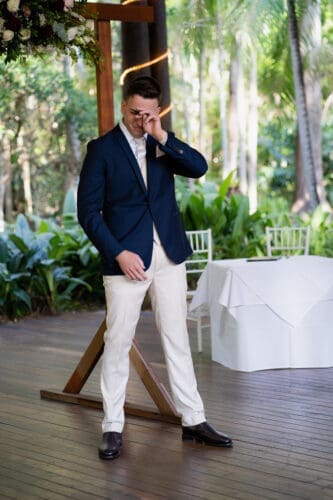 A groom is emotional and cries when he sees his bride walking down the aisle at Cedar Creek Lodges in Tamborine Mountain