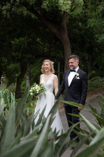 Laura and Rodrigo walking hand in hand through the vibrant pathways of Mt Coot-tha Botanic Gardens, enjoying the peaceful surroundings