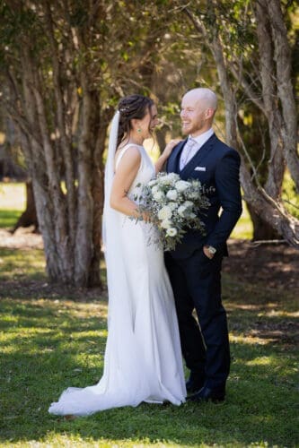 Bride and groom smiling during their first look at Ocean View Estates