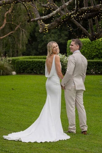Bride displays her backless dress by Made With Love Bridal
