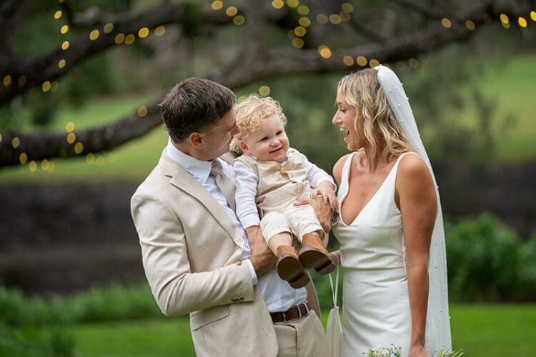 Candid family moment with bride, groom, and son at Braeside Gin House Creek Estate