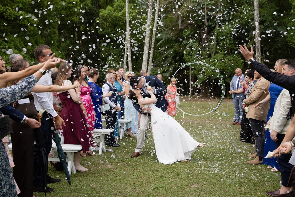Newlyweds celebrating with a rose petal toss and dip kiss at Boomerang Farm